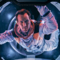 Astronaut Brian Harper (Patrick Wilson) peering into space inside the Space Shuttle in the sci-fi epic MOONFALL